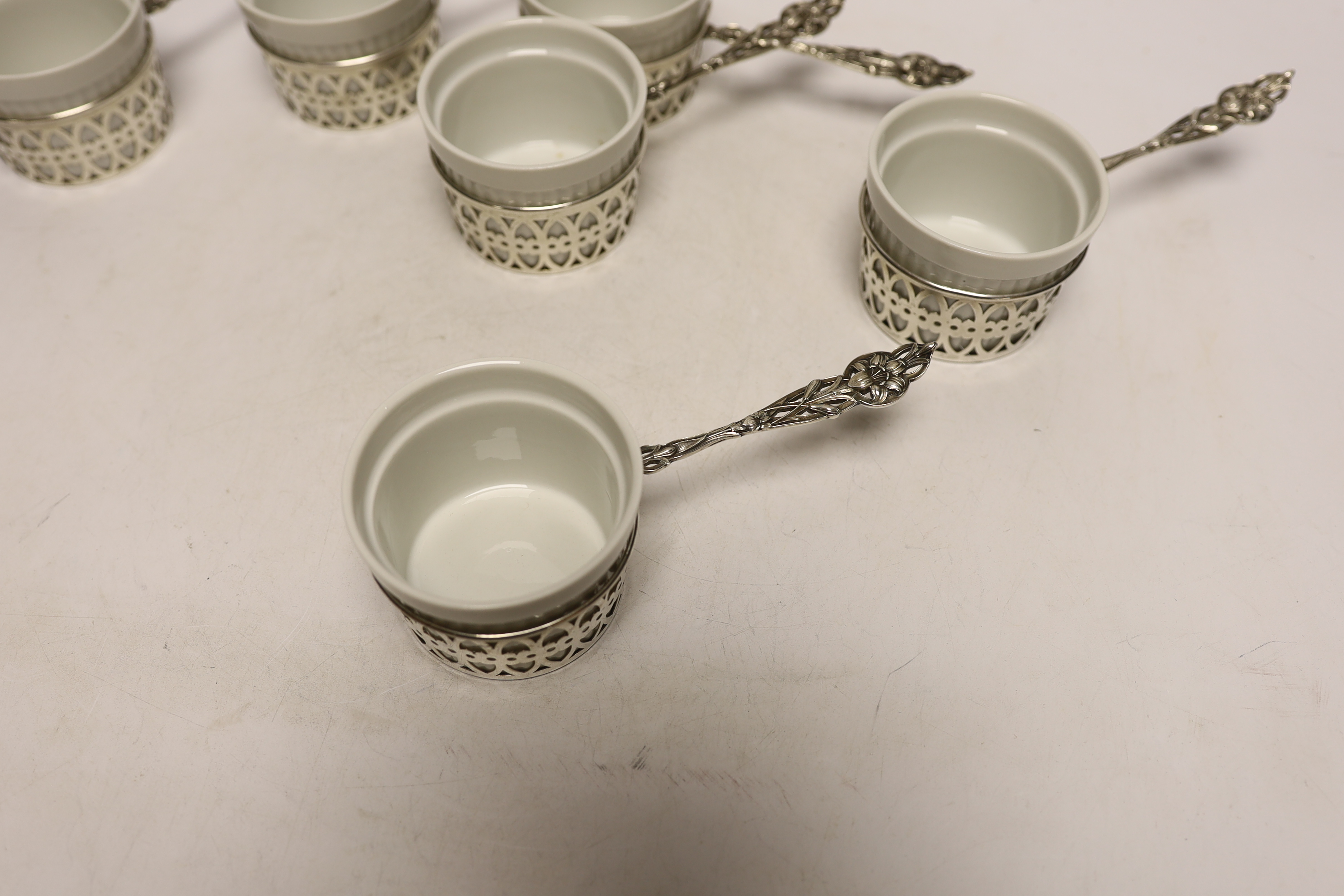 A set of six American sterling mounted handled ceramic soufflé holders, length 17cm.